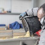 A man pours a bucket of shells.