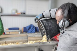 A man pours a bucket of shells.