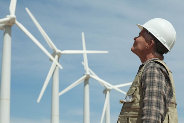 Man in hard hat looking at wind turbines.