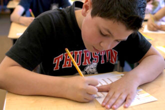 Picture of a boy filling out a We Have Choices daily tracker to monitor his self-regulation skills