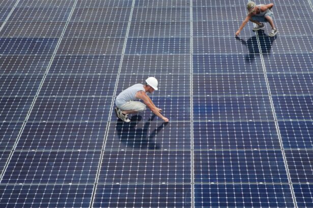 Two men installing solar panels on rooftop.