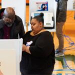 A poll worker helps a voter.