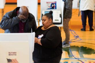 A poll worker helps a voter.