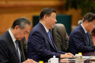 Chinese President Xi Jinping (center) and his delegation, including Foreign Minister Wang Yi (left), attend a meeting.