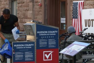 A poll worker collects mail in ballots from a drop box for the New Jersey primary election on June 4, 2024, in Hoboken, New Jersey