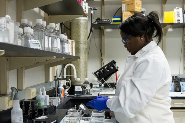 A woman in a scientific laboratory, wearing a lab coat and gloves.