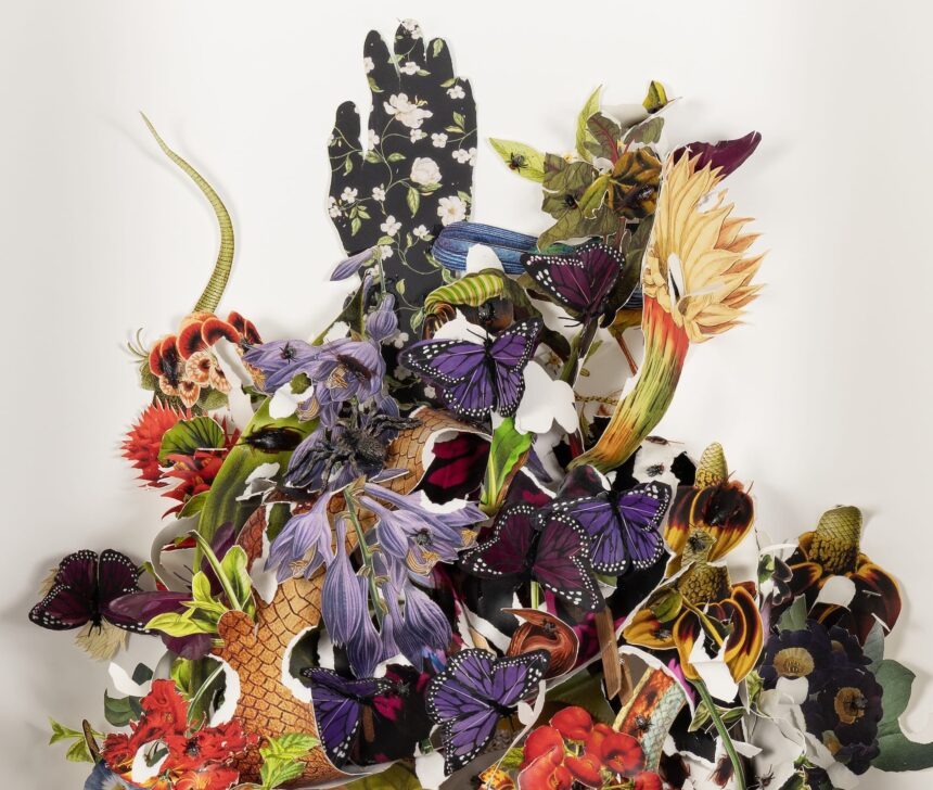 a detail of a paper assemblage artwork with cutouts of butterflies, snakes, and leaves, with a floral-patterned silhouette of a hand reaching out over the top