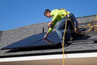 A man installing a solar panel on a rooftop.