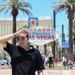 Person reacting to heatwave in front of Las Vegas sign