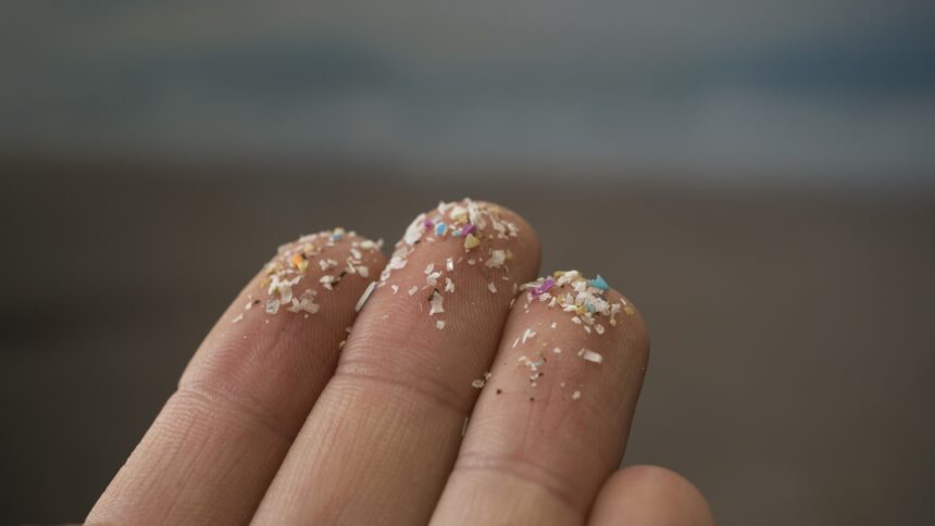 Closeup of fingers with microplastics on their tips.