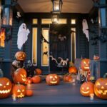 A porch decorated with ghosts and pumpkins for Halloween.