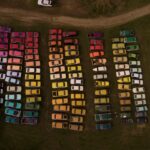 an aerial view of cars painted an arranged by color in a field