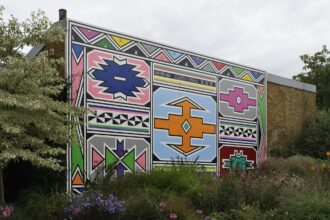 a mural depicting colorful Ndebele shapes and patterns outlined with a black border