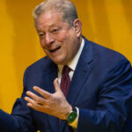 Photo of Al Gore talking with passion in front of an orange background