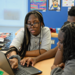 Photo of students working together on a computer