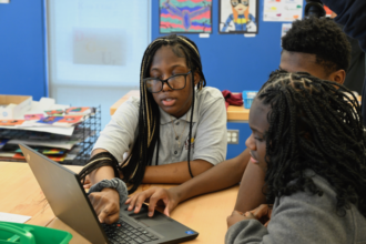 Photo of students working together on a computer