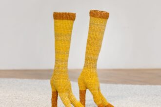 a pair of yellow woven straw boots shaped like bird legs