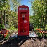 a red telephone booth in a park