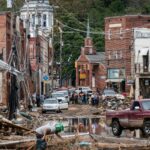 Workers, community members, and business owners clean up debris in the aftermath of Hurricane Helene in Marshall, North Carolina on Monday, Sept. 30, 2024.