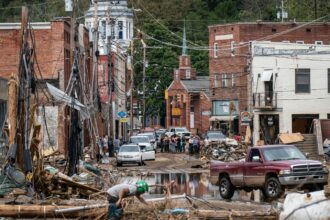 Workers, community members, and business owners clean up debris in the aftermath of Hurricane Helene in Marshall, North Carolina on Monday, Sept. 30, 2024.