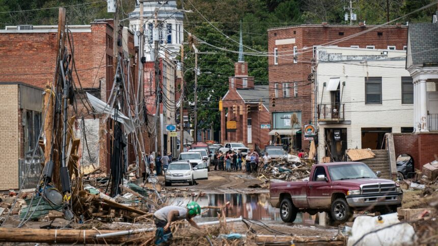 Workers, community members, and business owners clean up debris in the aftermath of Hurricane Helene in Marshall, North Carolina on Monday, Sept. 30, 2024.