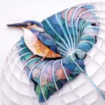 a quilled paper sculpture of a kingfisher in a leaf