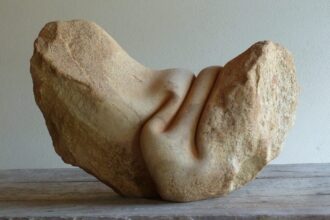 a sculpture made from stone that has been carved to appear as though it is wrinkled like fabric or skin on the top