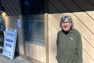 Byrdene Byerly, who lost her home in Yancey County from floods caused by Hurricane Helene, stands outside a polling place after voting for Kamala Harris.