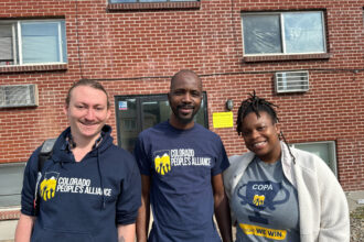 Julian Temianka, Lamine Kane and Jojo Franklin, organizers at Colorado People’s Alliance, stand outside the apartment complex in Aurora, Colorado, that former President Donald Trump has said is gang riddled, on Oct. 11.