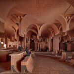 the interior of a cinema lobby made in a contemporary style with curved brickwork