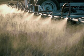 A machine sprays pesticides over a field.