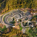 an aerial view of an elaborate hillside garden and landscape design inspired by the curling forms of Vincent van Gogh's painting, "The Starry Night"