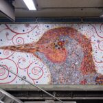 a mosaic mural of a bird in a New York City subway station