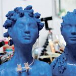 two blue busts, one with a gold necklace featuring two chairs