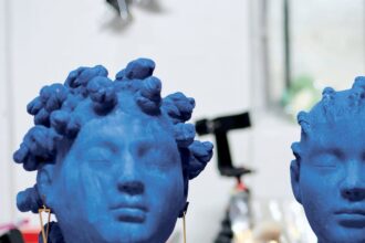 two blue busts, one with a gold necklace featuring two chairs