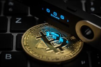 The word Bitcoin can be seen on the display of a Ledger Nano S hardware wallet next to a symbolic "Bitcoin coin". Photo: Silas Stein/dpa (Photo by Silas Stein/picture alliance via Getty Images)