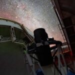 A telescope instrument is pointed at a starry sky.