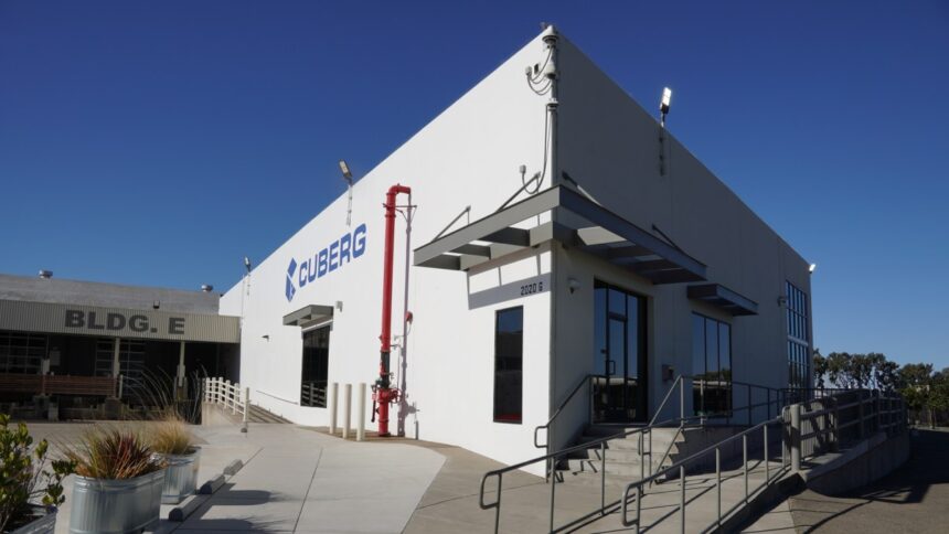 Cuberg's old manufacturing facility stands against a blue sky.