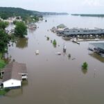 A small town is inundated by brown flood waters