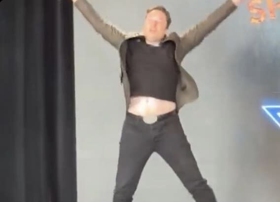 Elon Musk jumping up and making an X with his body