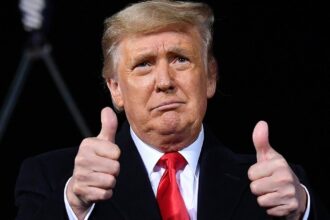 Then-President Donald Trump holds two thumbs up at a campaign rally for incumbent Sens. Kelly Loeffler and David Perdue ahead of Senate runoff in Dalton, Georgia on Jan. 4, 2021.