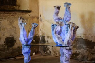 a sculptural table with coral-like forms on each side made from violet-colored woven fabric