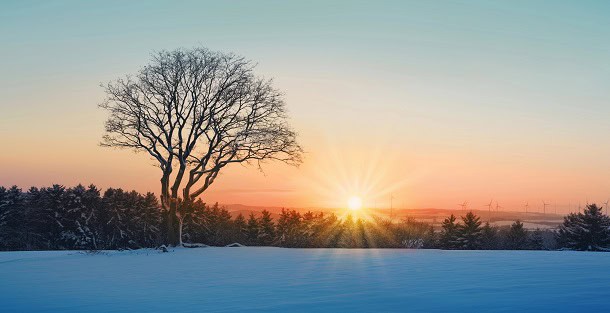 A sunrise in January over a cold and snowy landscape.