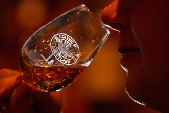 A whiskey drinker savors the aromas in a glass.