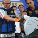 Indonesian customs officials destroy a smuggled iPhone 16 Pro Max that was confiscated alongside dozens of Apple phones and tablets, at the customs office of SoekarnoHatta International Airport in Tangerang, Banten, on November 29, 2024.