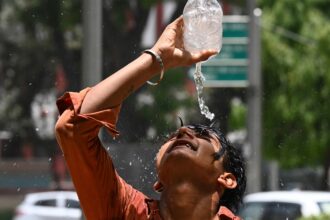 A boy in India pours water over his head.