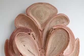 a symmetric pink coiled wall sculpture