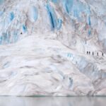 a group of people walking on a large glacier