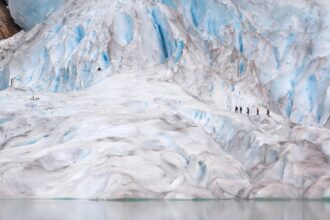 a group of people walking on a large glacier