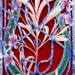 the side view of a painting on wood and velvet of otherworldly pink and purple flowers behind an ornate barrier reminiscent of wrought iron